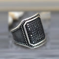 Black alloy ring with a zircon stone and copper inlay detail, shown in a unisex style.