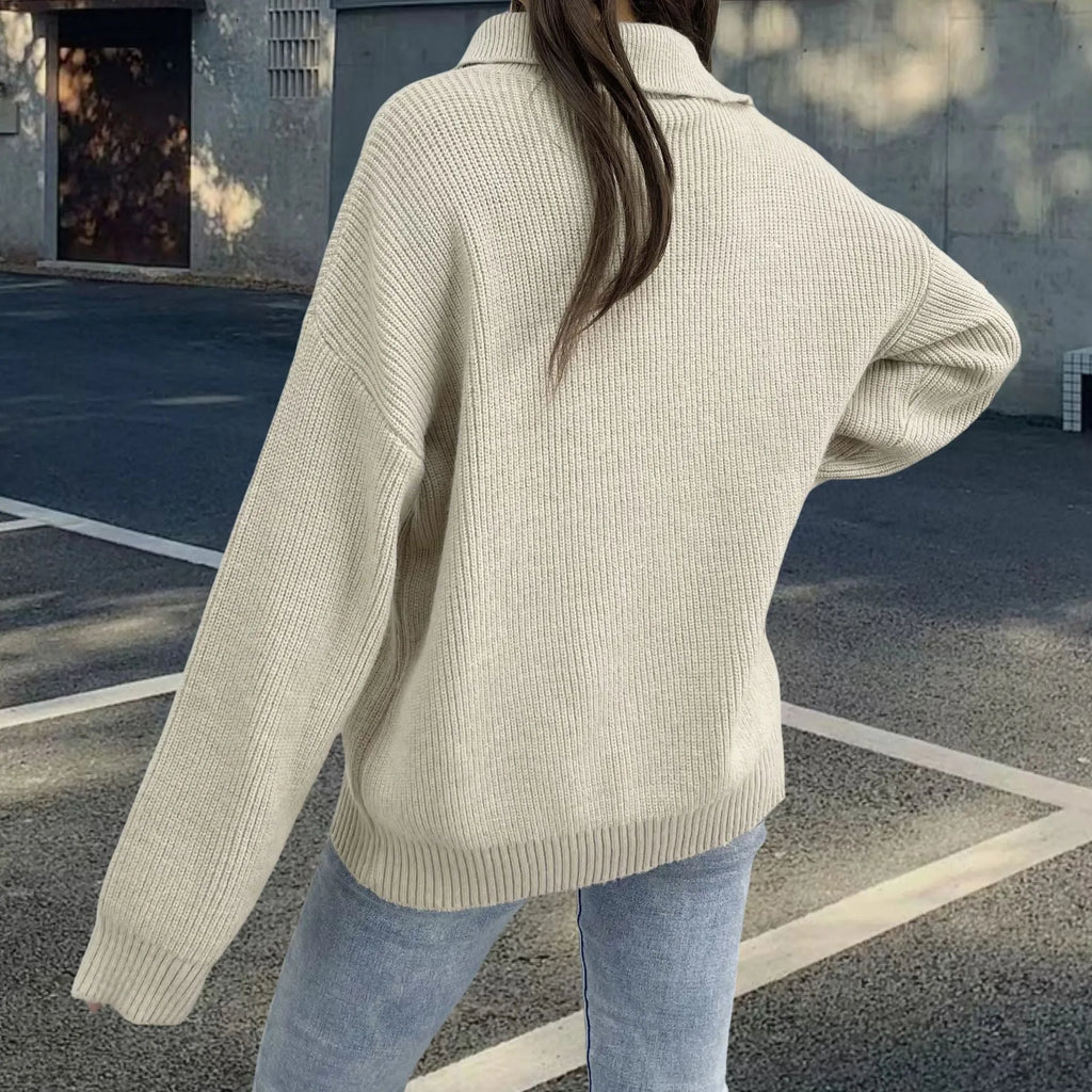 Woman wearing a light khaki retro turtleneck sweater with loose lapels and an oblique diagonal zipper detail.