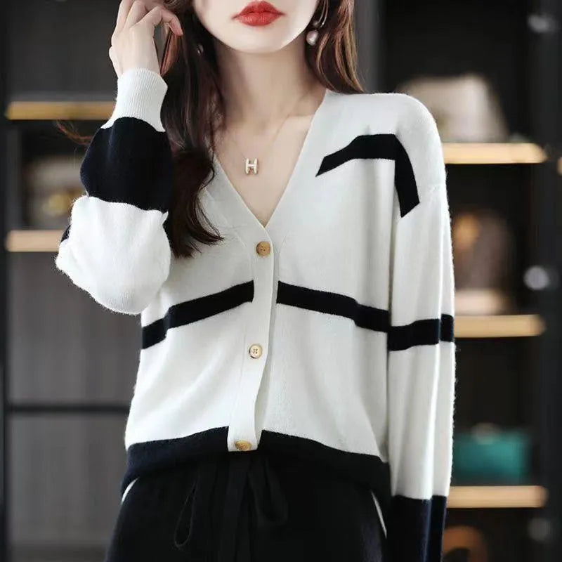 Women's black and white striped V-neck knitted cardigan with 3D pattern on a hanger.