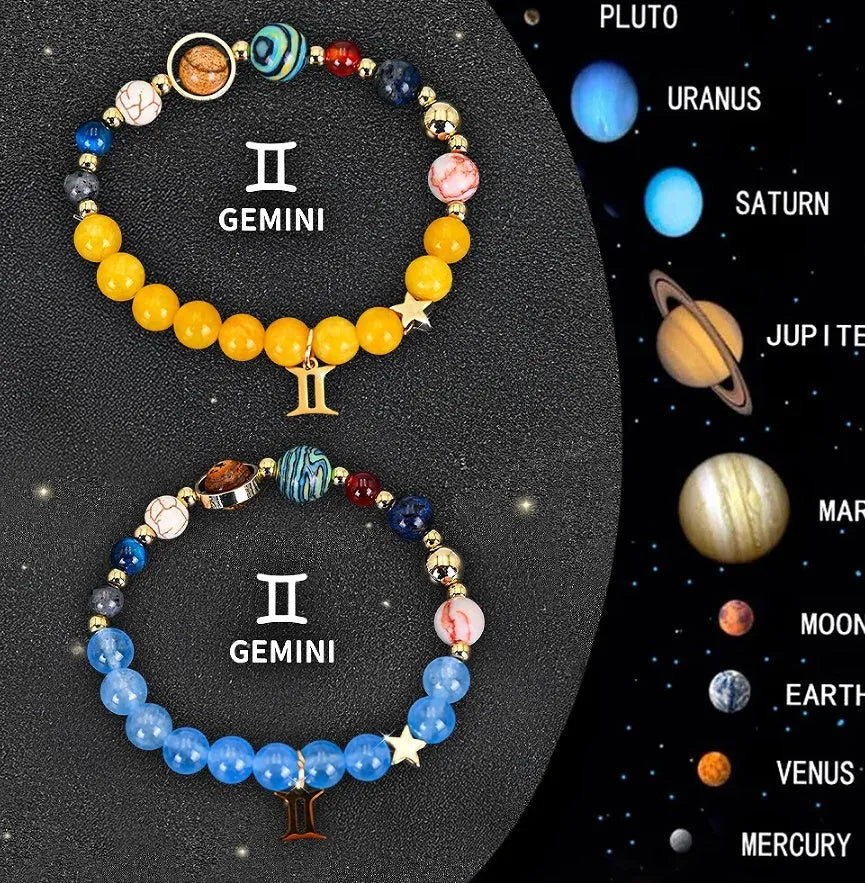 Two natural stone beaded bracelets with zodiac sign charms on a wooden surface