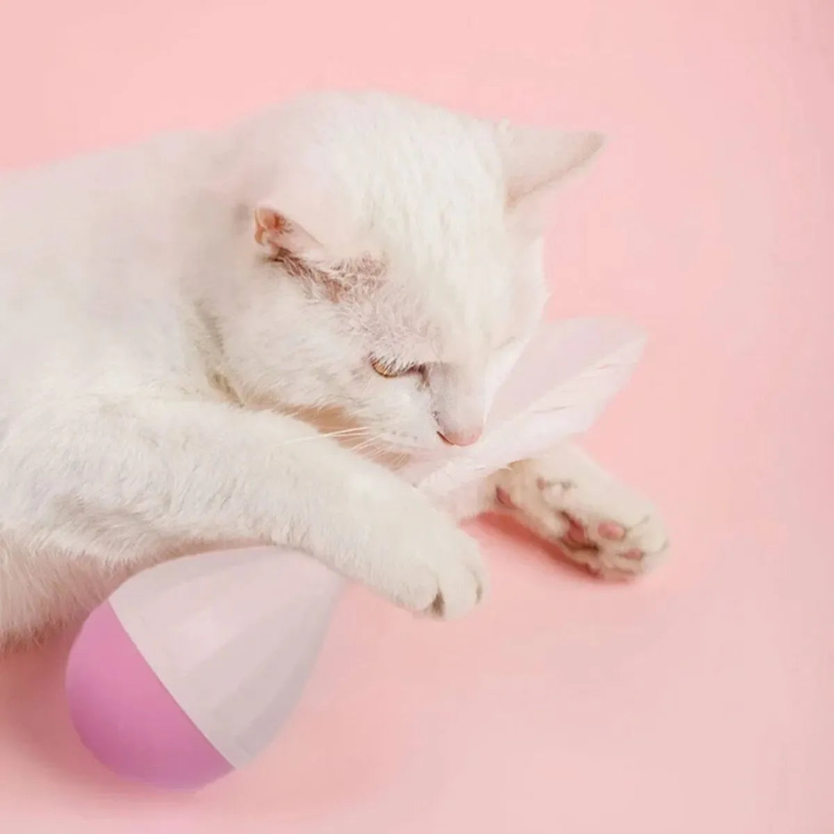 Feather Tumbler Cat Toy with goose feathers and aluminium alloy construction on pink background