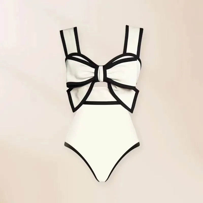 Women's black one-piece swimsuit with a white bow and attached round skirt.