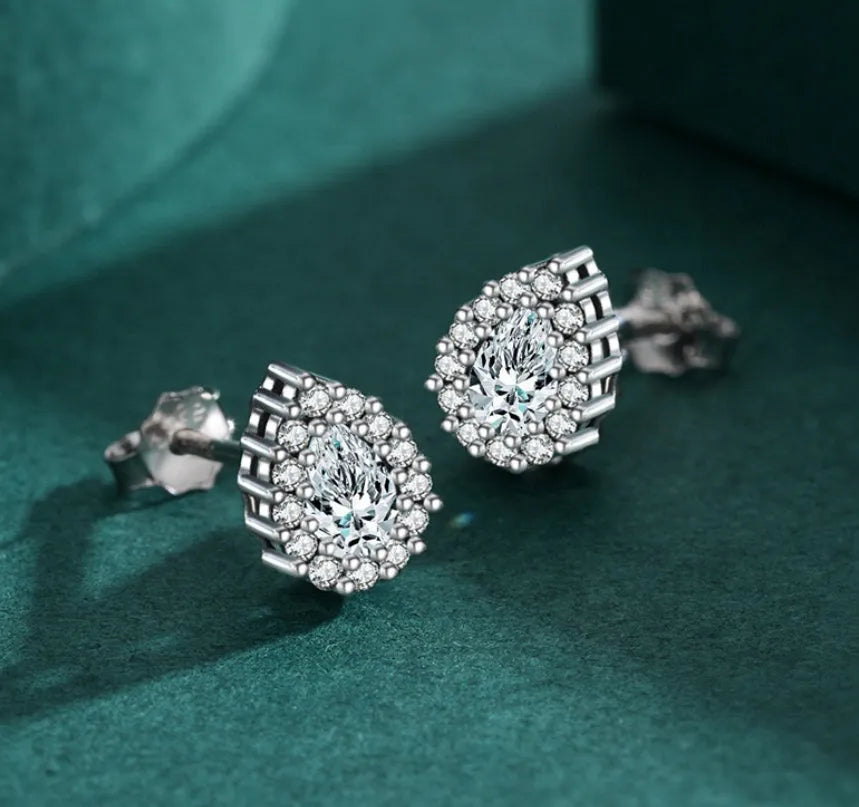 A pair of silver water drop shaped stud earrings with a diamond-cut faceted surface.