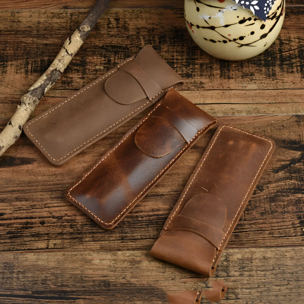 Brown leather pencil case with zip opening on a plain background