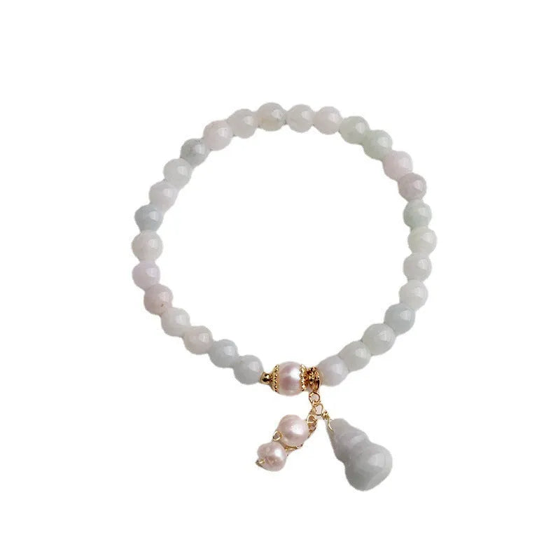 Emerald green jade bracelet with hand-carved gourd charm and pearl decoration in Chinese style