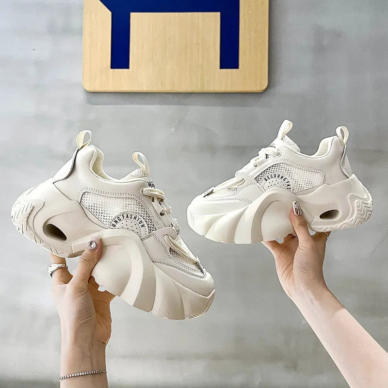 Women's beige casual sneakers with cross straps and a thick mid-height sole, shown from the side.