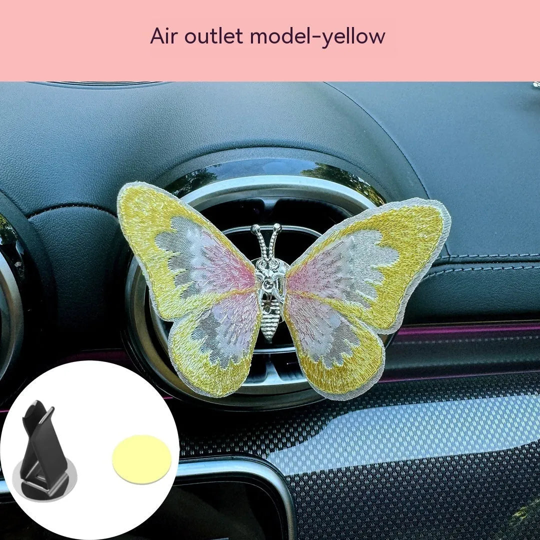 Moving embroidery butterfly decoration on car centre console air vent in pink fabric
