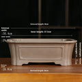 Rectangular antique purple sand bonsai planter with corner-cut design on floor.
