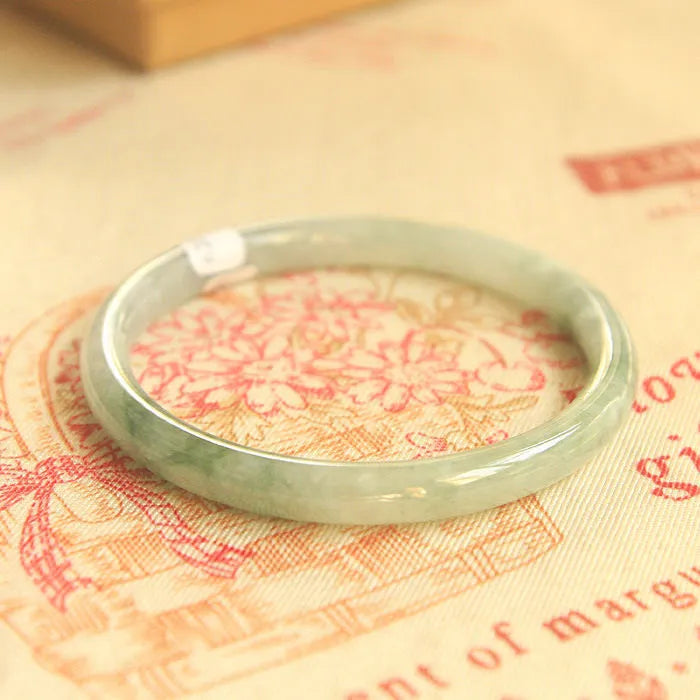 Green jade waxy geometric Chinese style bracelet showing 10mm width on wrist.
