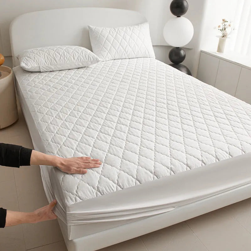 Diamond lattice quilted waterproof mattress protector and pillowcases in a solid colour.