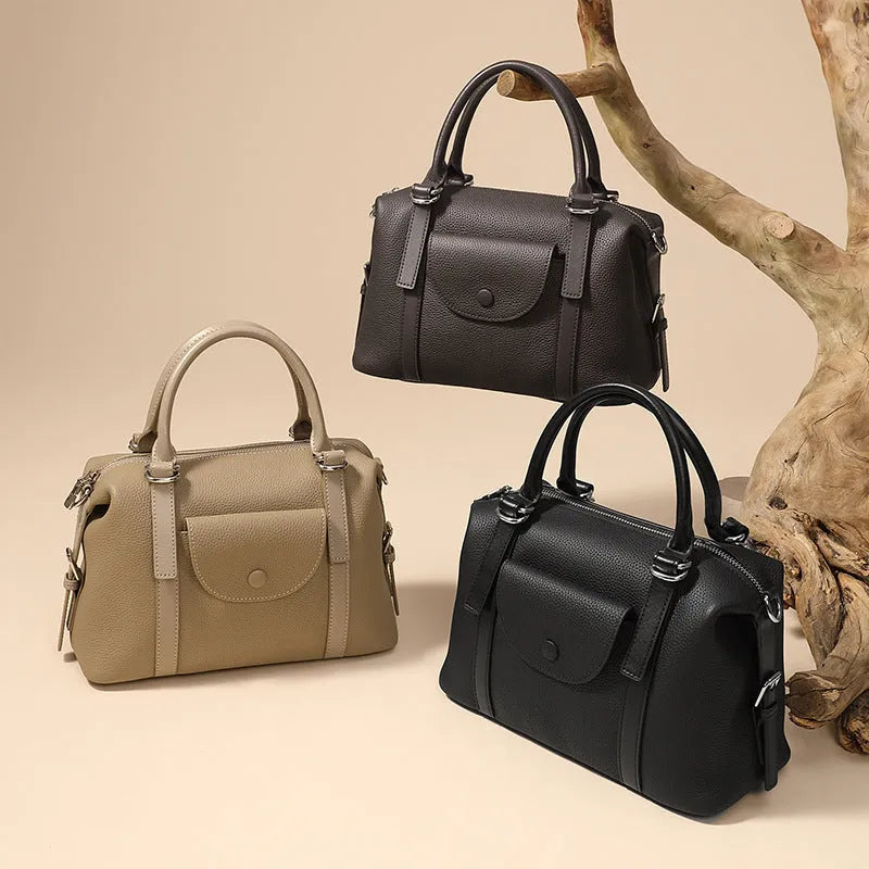 Genuine leather ladies handbag in street trend style with contrast stitching and lock detail.