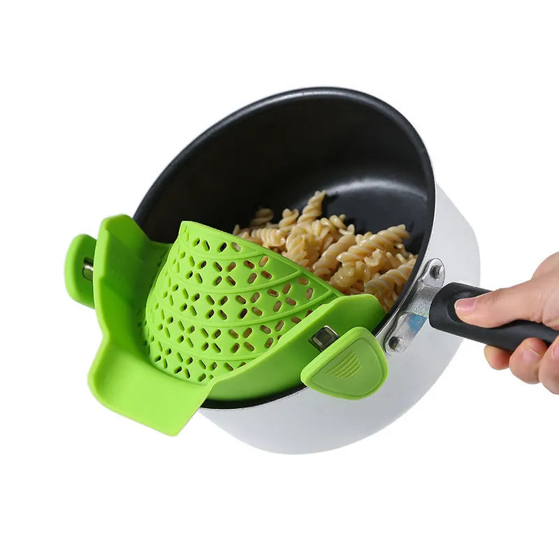 Silicone pot side drain stopper in black attached to saucepan rim with leak-proof edge