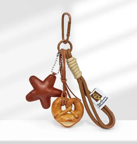 Handmade resin handbag pendant with soda bread designs including cartoon croissant and brown stars