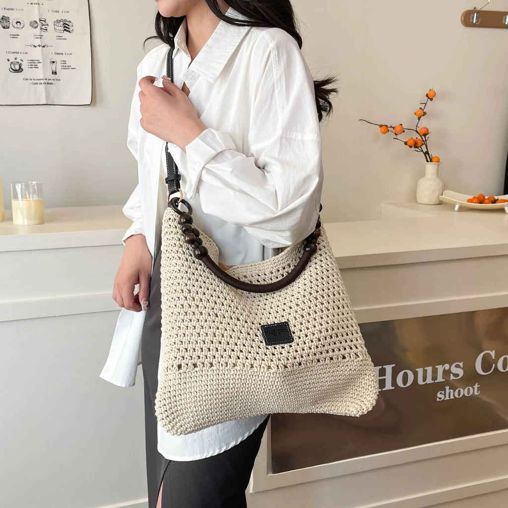 Knitted tote beach bag with contrast stitching showing crossbody strap and zip compartment