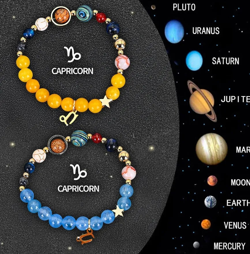 Two natural stone beaded bracelets with zodiac sign charms on a wooden surface