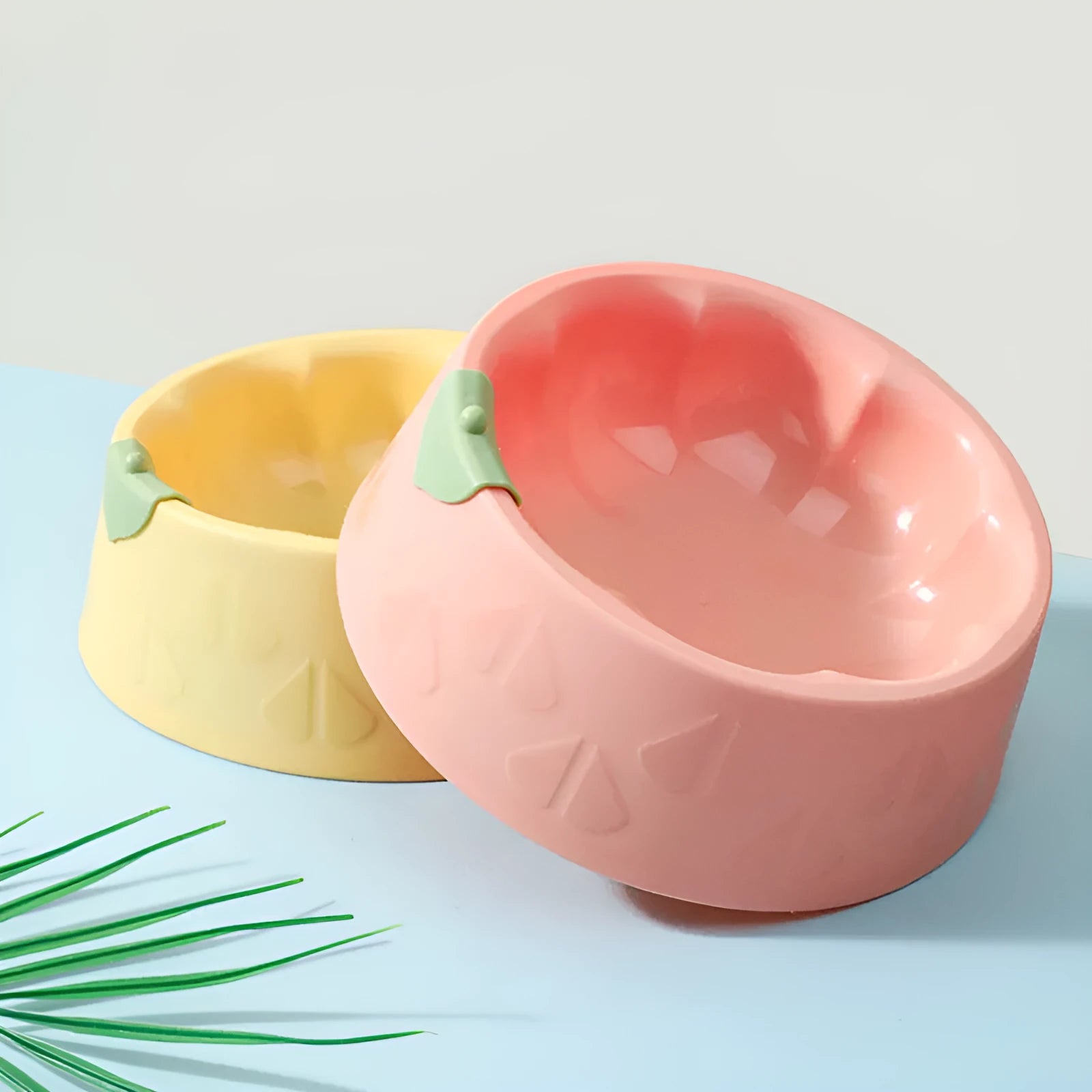 Green plastic double pet bowl for dog and cat food and water on a white surface