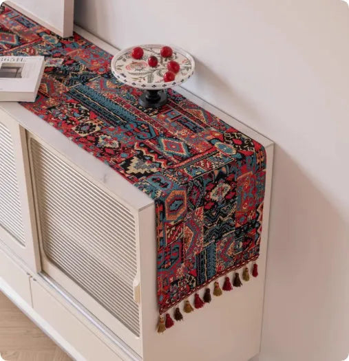 Country European retro style table flag with long handwoven tassels draped over a wooden sideboard.