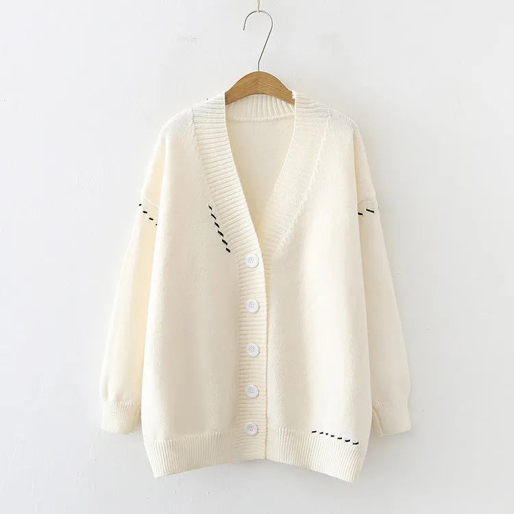 Women's loose fit black knitted cardigan coat with long sleeves on a hanger.