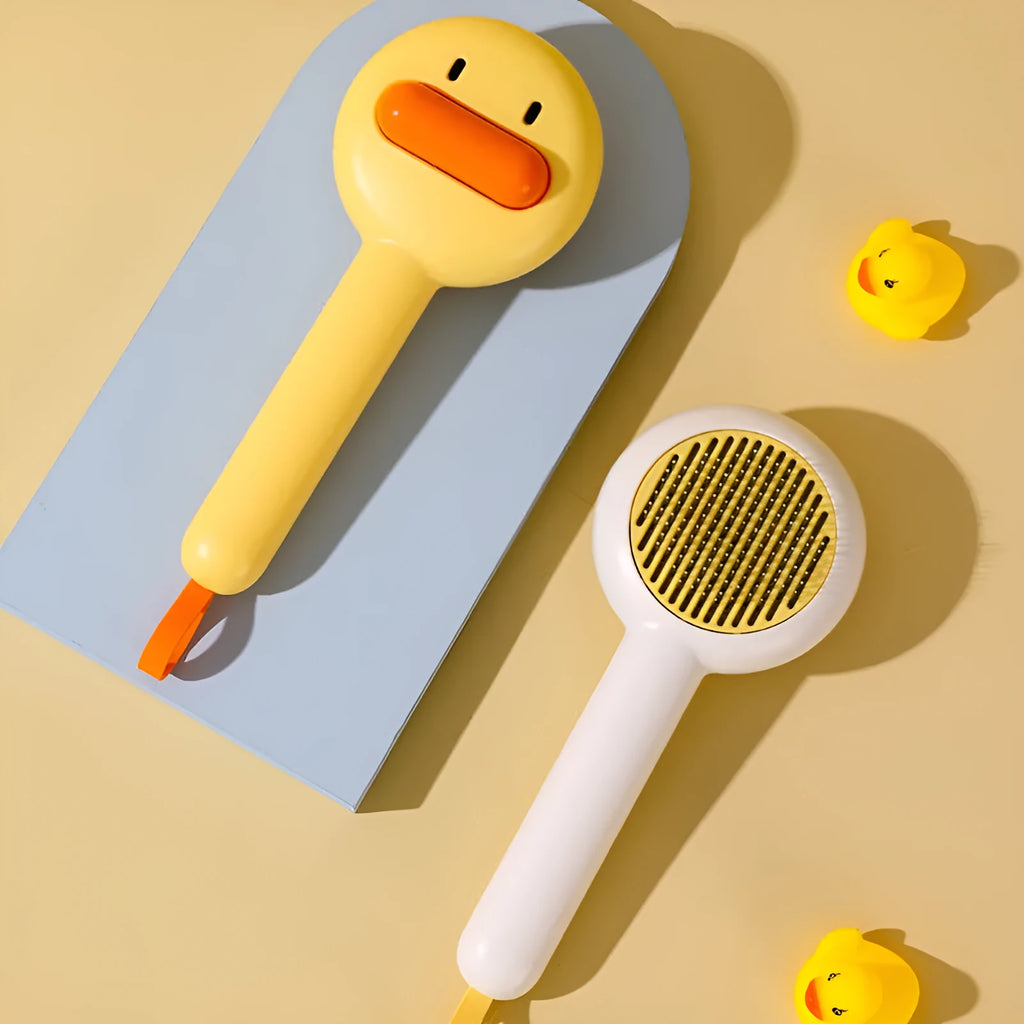 Small yellow duck-shaped comb for pet grooming with needle points and floating hair removal device