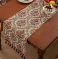 Country European retro style table flag with long handwoven tassels draped over a wooden sideboard.