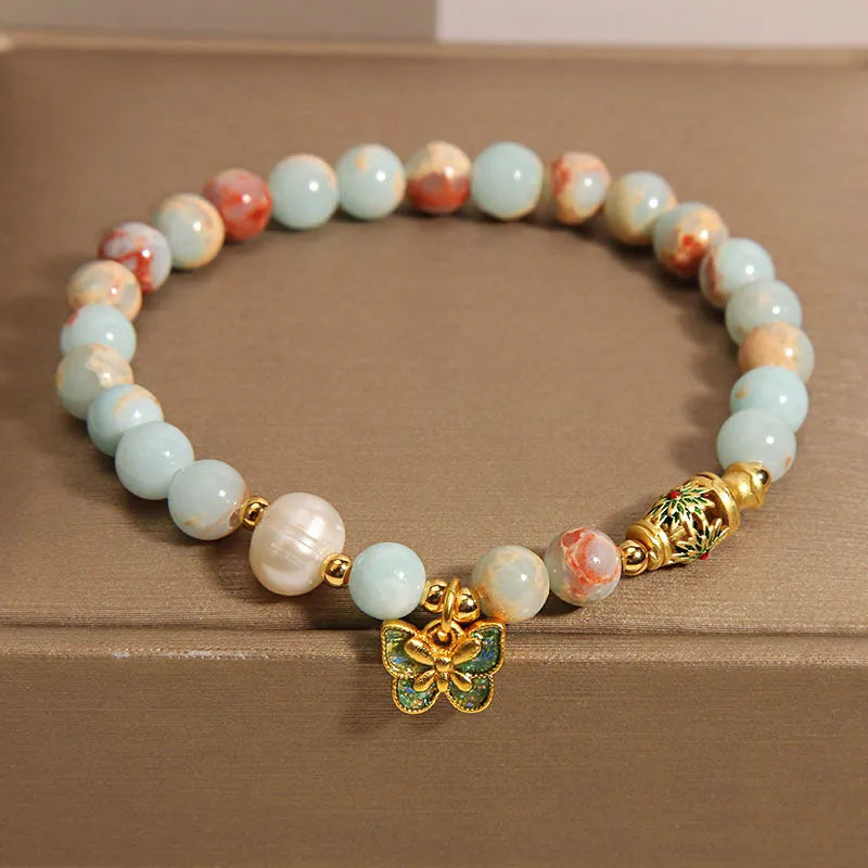 Shoushan stone and freshwater pearl bracelet with blue butterfly pendant on display