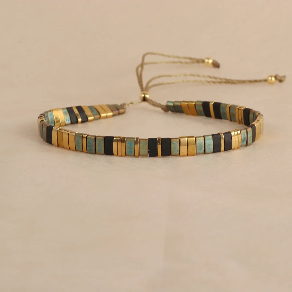 Geometric pull bead bracelet in milky white glass beads on a wrist.