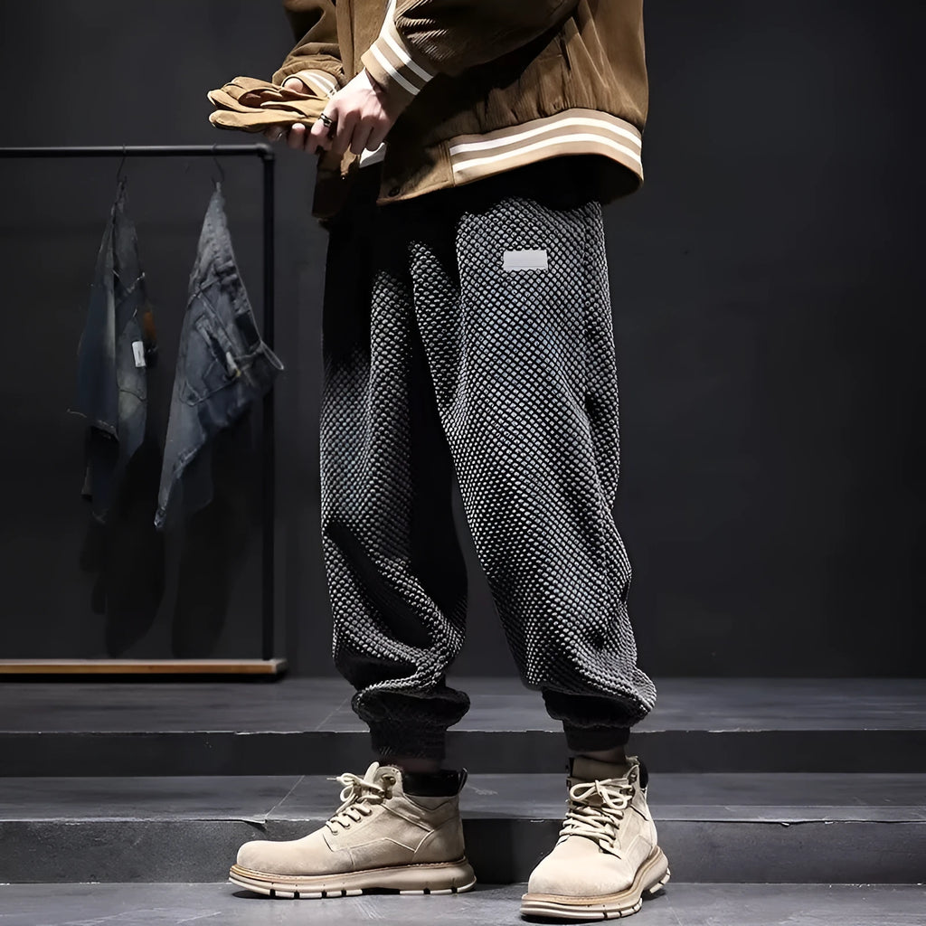 Men's grey ankle-tied straight leg sweatpants laid flat on a surface.
