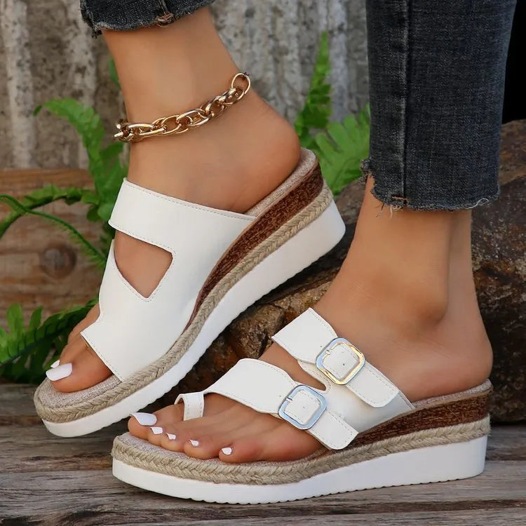 White patent leather wedge sandals with peep toe and woven design on model