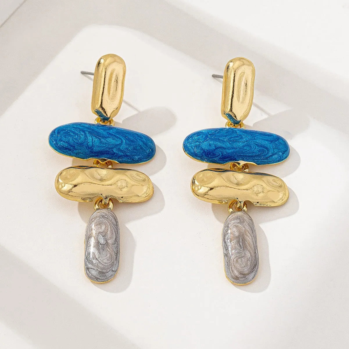 A pair of simple geometric stud earrings with a multicolour electroplated finish.