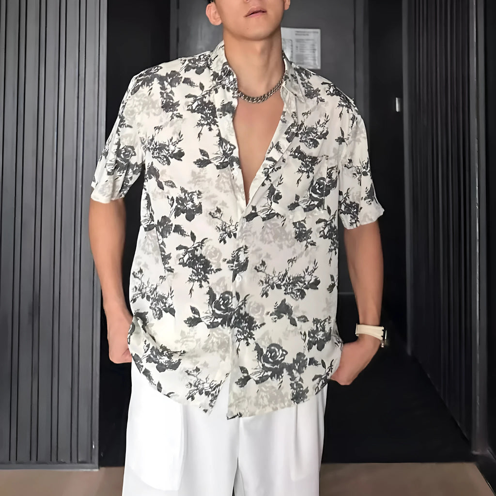 Man wearing a loose black floral print casual short sleeve shirt.