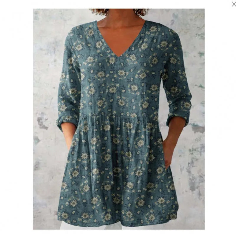 A woman wearing a loose-fitting printed dress with 3/4 sleeves and a wide waist.