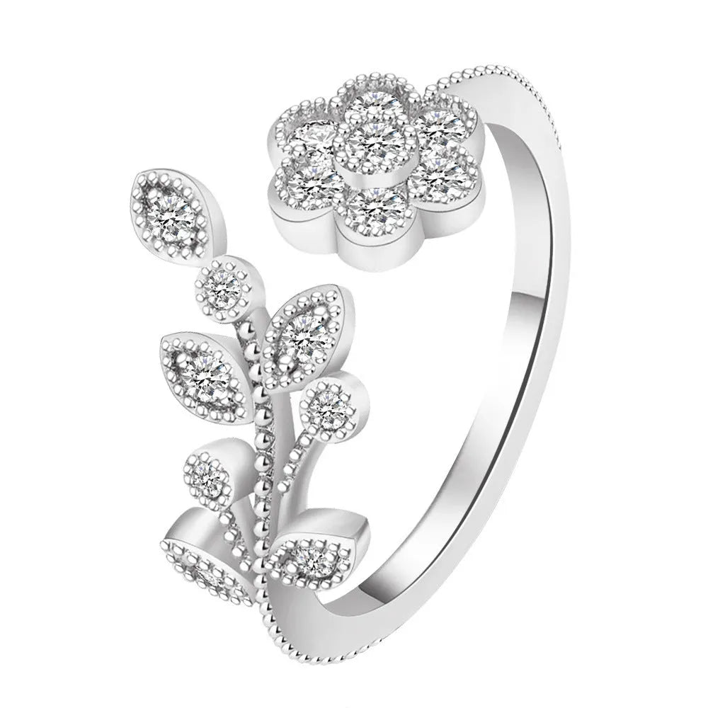 Women's open ring with floral leaf design in gold tone on white background