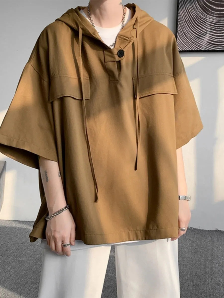 A man wearing a loose-fit black hooded short sleeve t-shirt made of polyester for summer.
