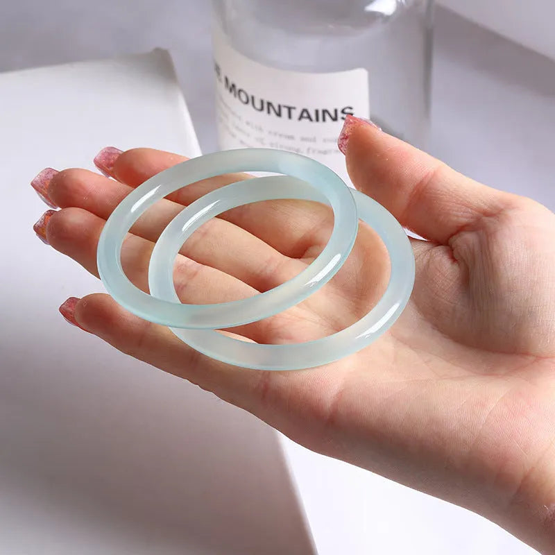 Azure light blue water ice quartzite jade thin round bar bracelet on white background
