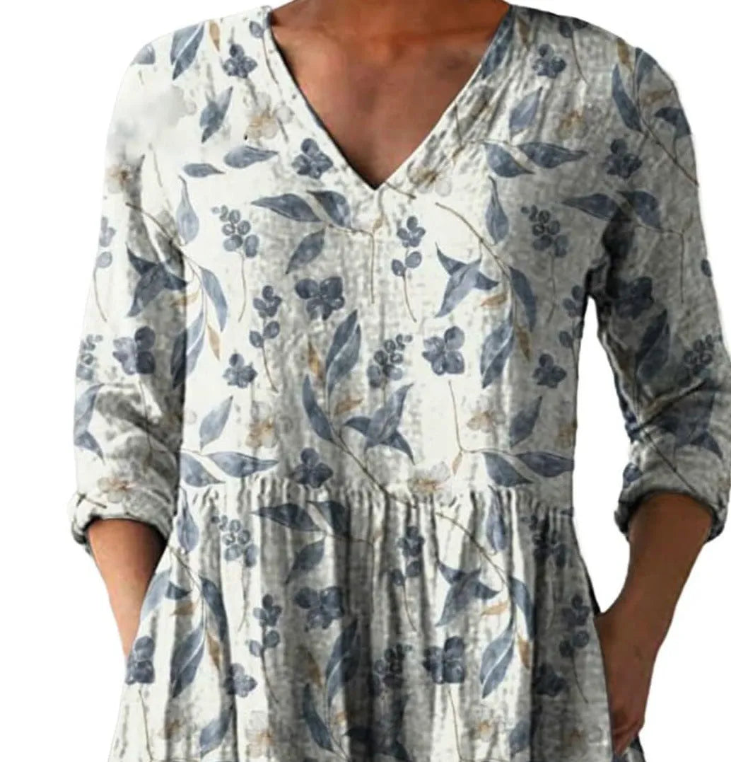 A woman wearing a loose-fitting printed dress with 3/4 sleeves and a wide waist.