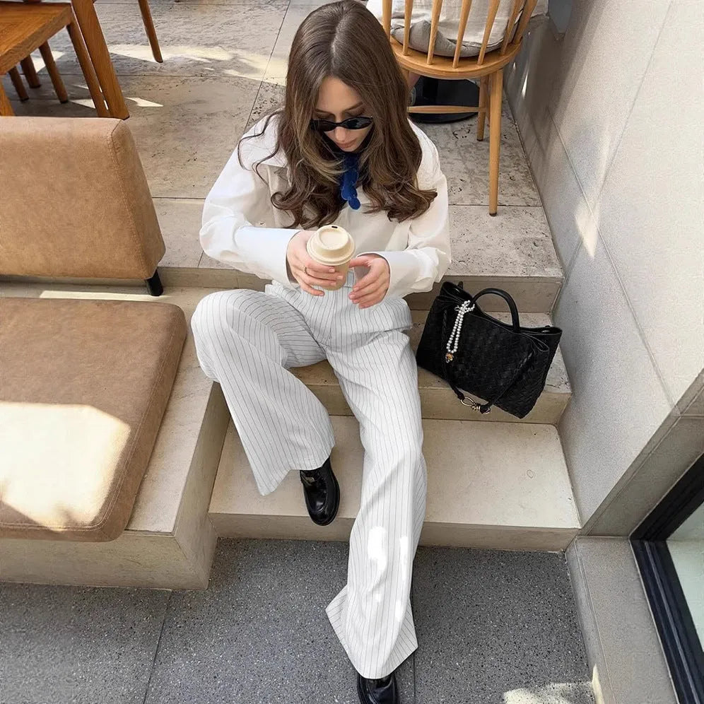 White striped wide-leg casual trousers with a zip closure on a hanger.