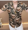 Men's fashion print shirt with all-over multicolor design, long sleeves, and button front, shown on a model.