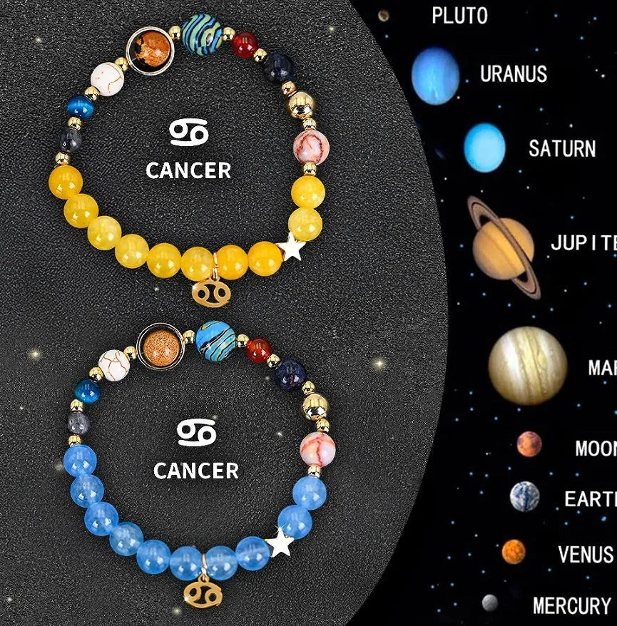Two natural stone beaded bracelets with zodiac sign charms on a wooden surface