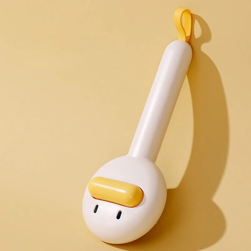 Small yellow duck-shaped comb for pet grooming with needle points and floating hair removal device