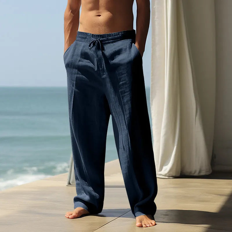 Men's loose casual cotton trousers in solid colours showing black, grey, and khaki options on a hanger.