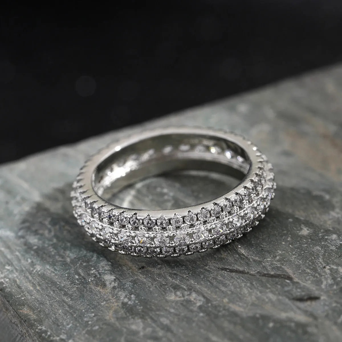 Geometric triangle engagement ring with zircon stone in yellow gold finish on a copper band.