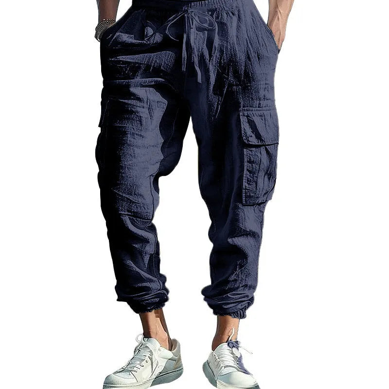Man wearing khaki linen casual trousers with ankle-tied legs and multiple pockets.