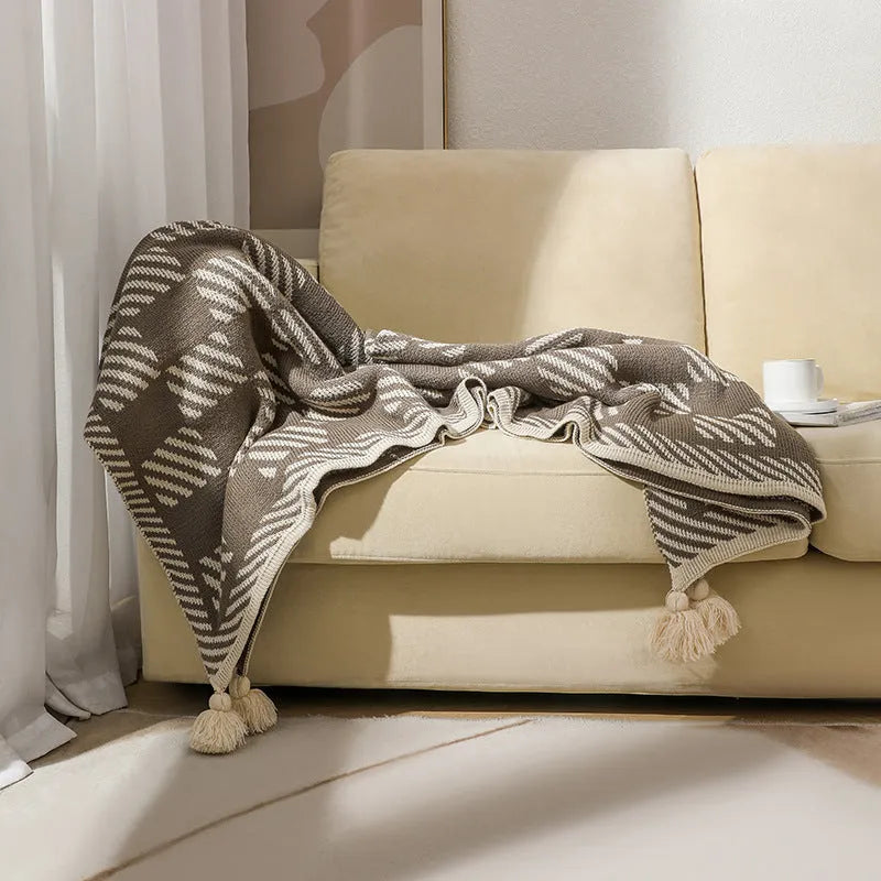 Acrylic sofa blanket with tassel fringe in geometric pattern, showing 130 cm width measurement