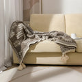 Acrylic sofa blanket with tassel fringe in geometric pattern, showing 130 cm width measurement