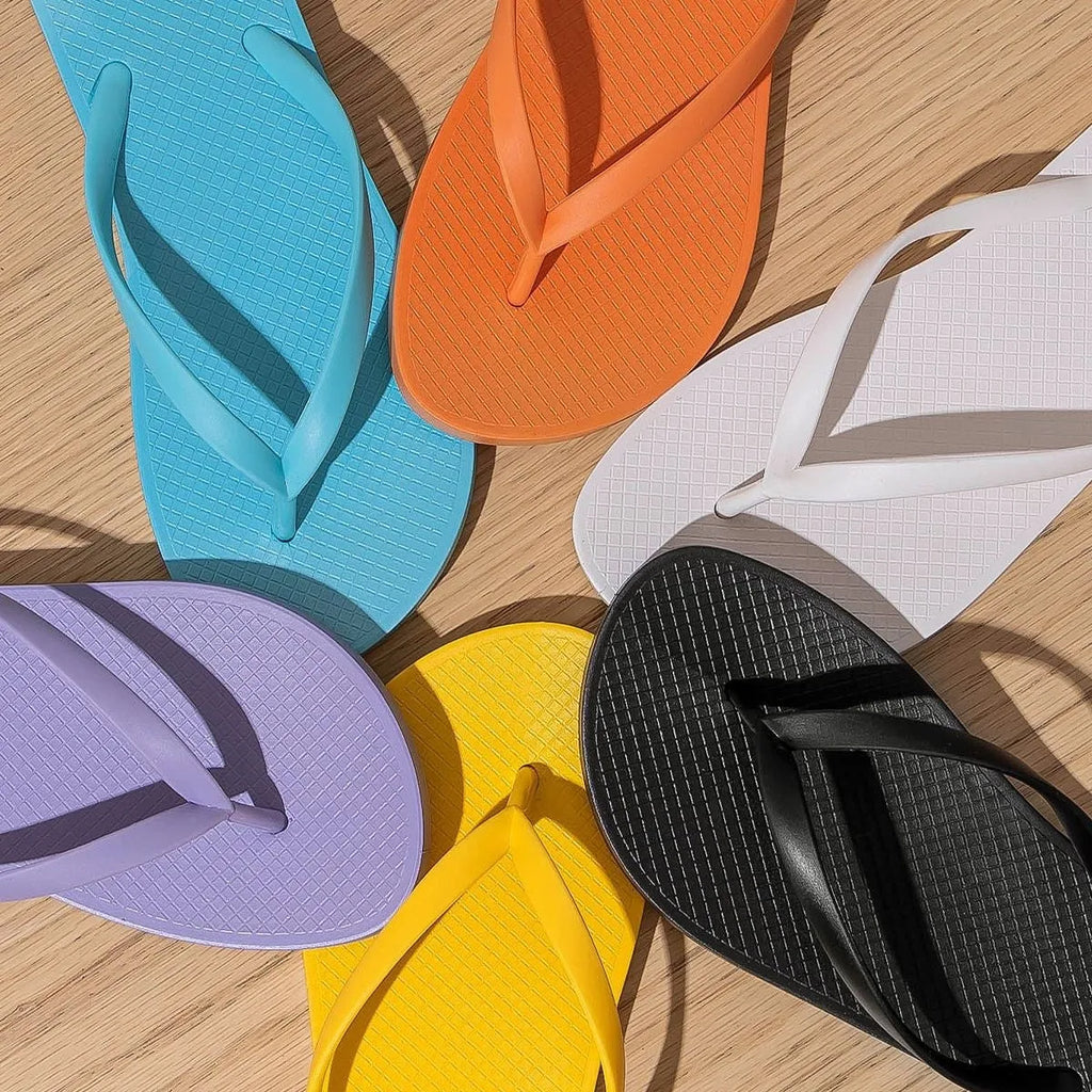 Foldable orange beach slippers showing hollow-out breathable design and non-slip PVC sole.