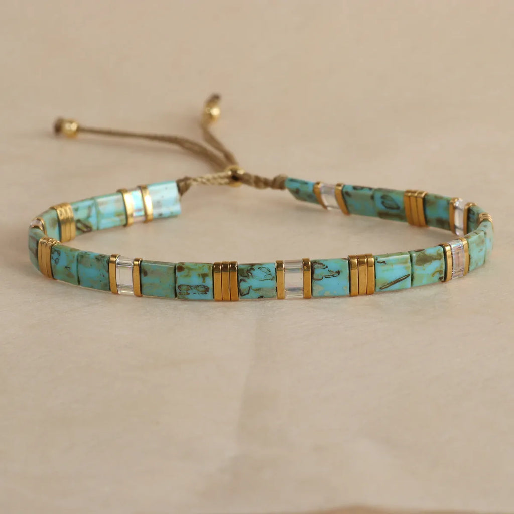 Geometric pull bead bracelet in milky white glass beads on a wrist.