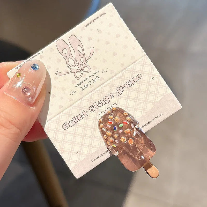 Close-up of a handmade resin hair barrette with a cute cartoon ice cream design in a choice of colours.