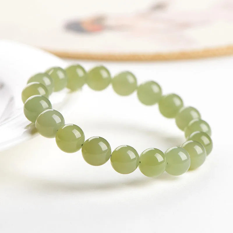Polished Hetian jade bead bracelet in ice-like clear water colour on a wrist.
