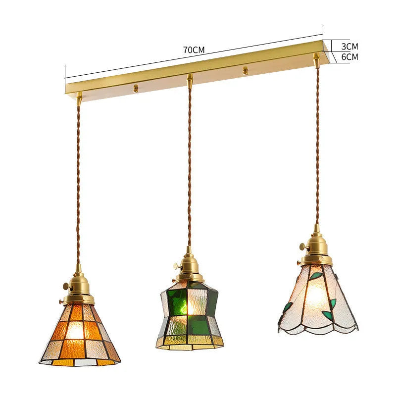 Retro brass and hand-blown glass chandelier with a hemp rope light line hanging from a ceiling.