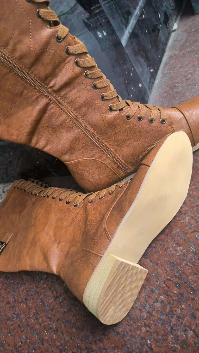 Women's black PU leather knee-high boots with a cross strap detail across the ankle.